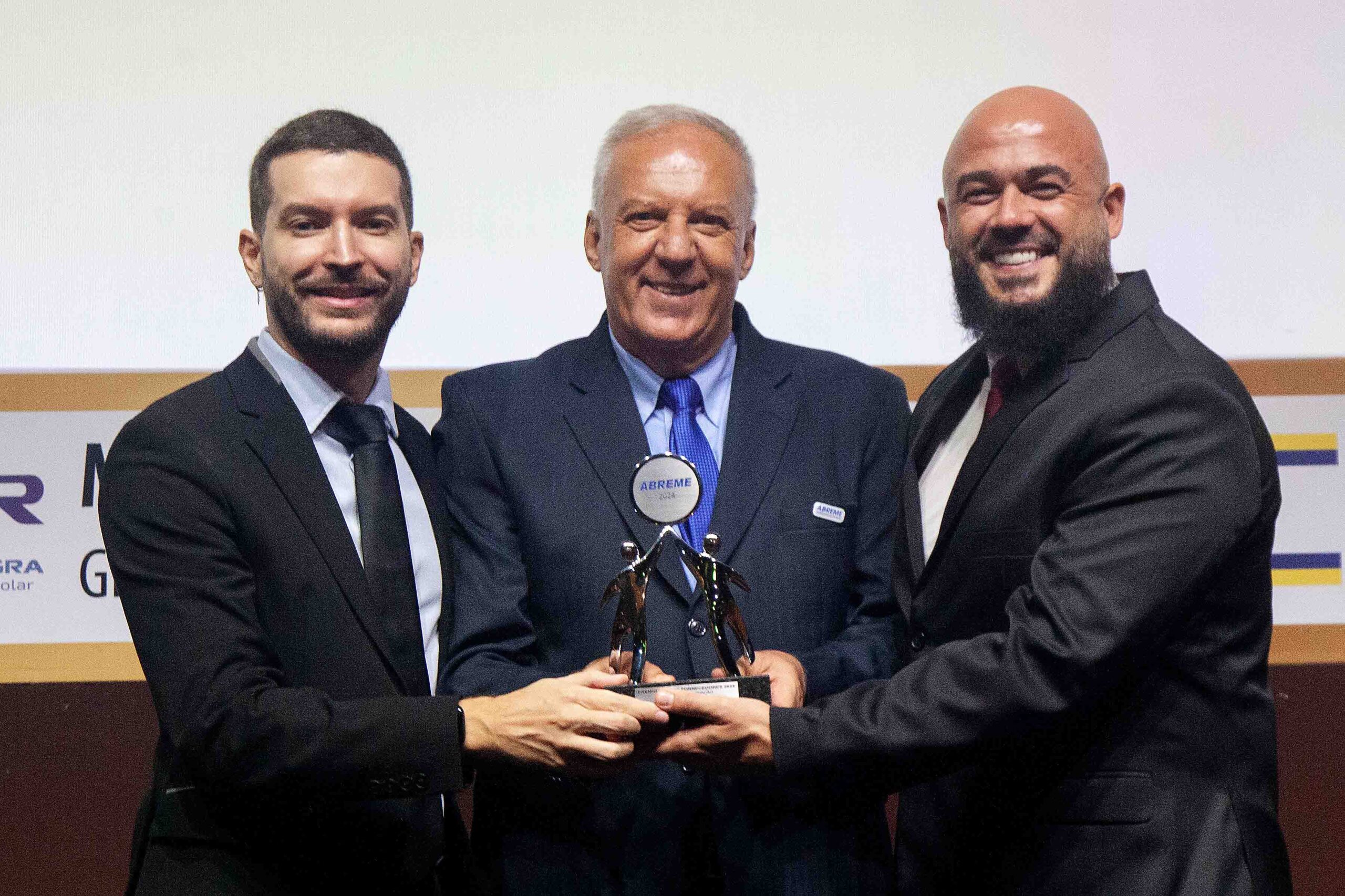 Diretor ABREME Sr. Francisco Simon entrega aos Srs. Wesley Pazini Diretor Comercial e Marketing e Vinicius Barretos Gerente de Marketing da empresa AVANT LUX troféu Prata 2024 segmento Iluminação.