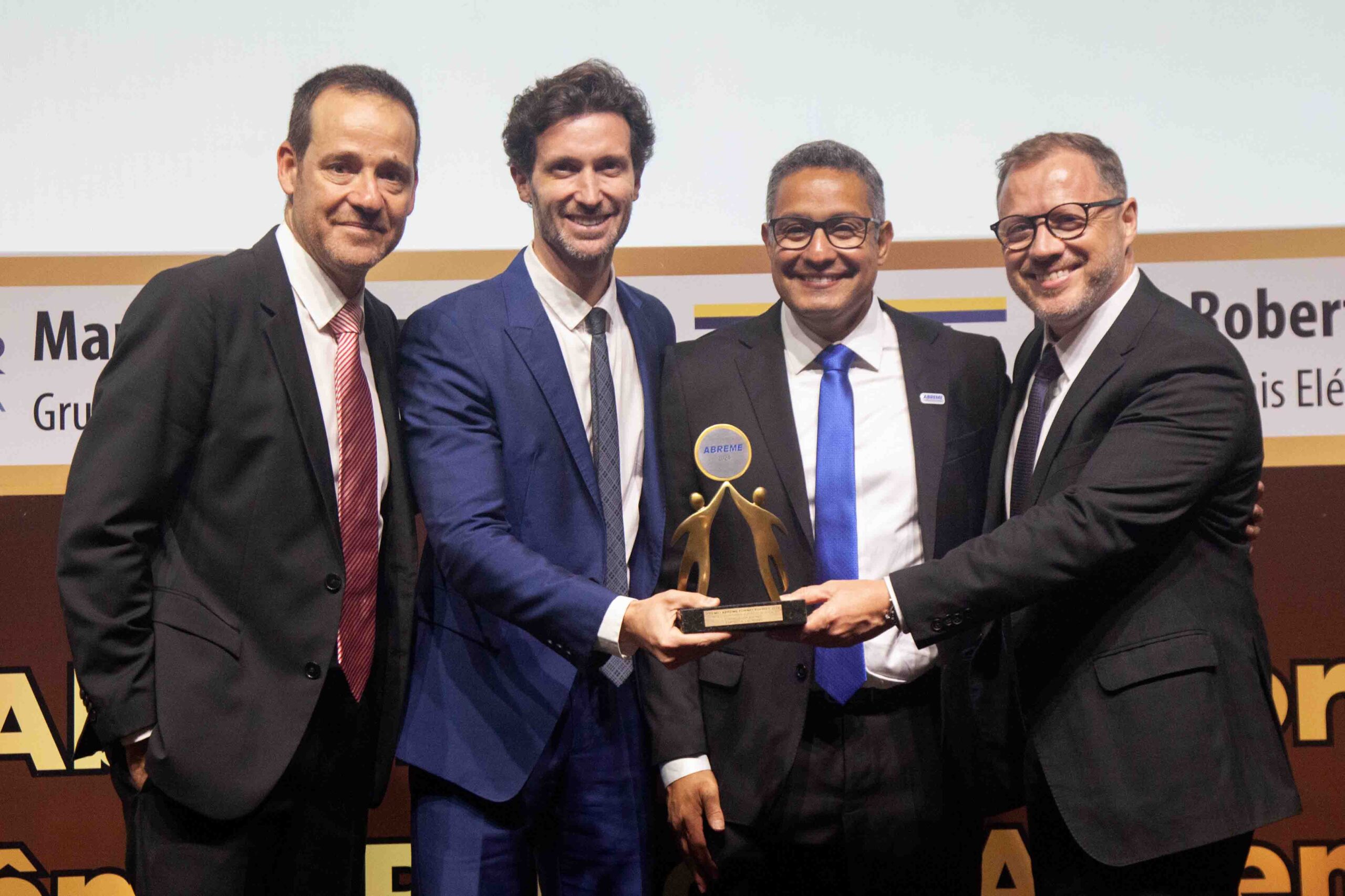 Diretor ABREME Sr. Thiago Espinheira Ferreira entrega aos Srs. Daniel Tatini Presidente, Thiago Freccia Gerente Nacional de vendas e Nelson Rebelato Diretor da empresa LEGRAND troféu Bronze 2024 segmento Dispositivos Elétricos Residenciais.