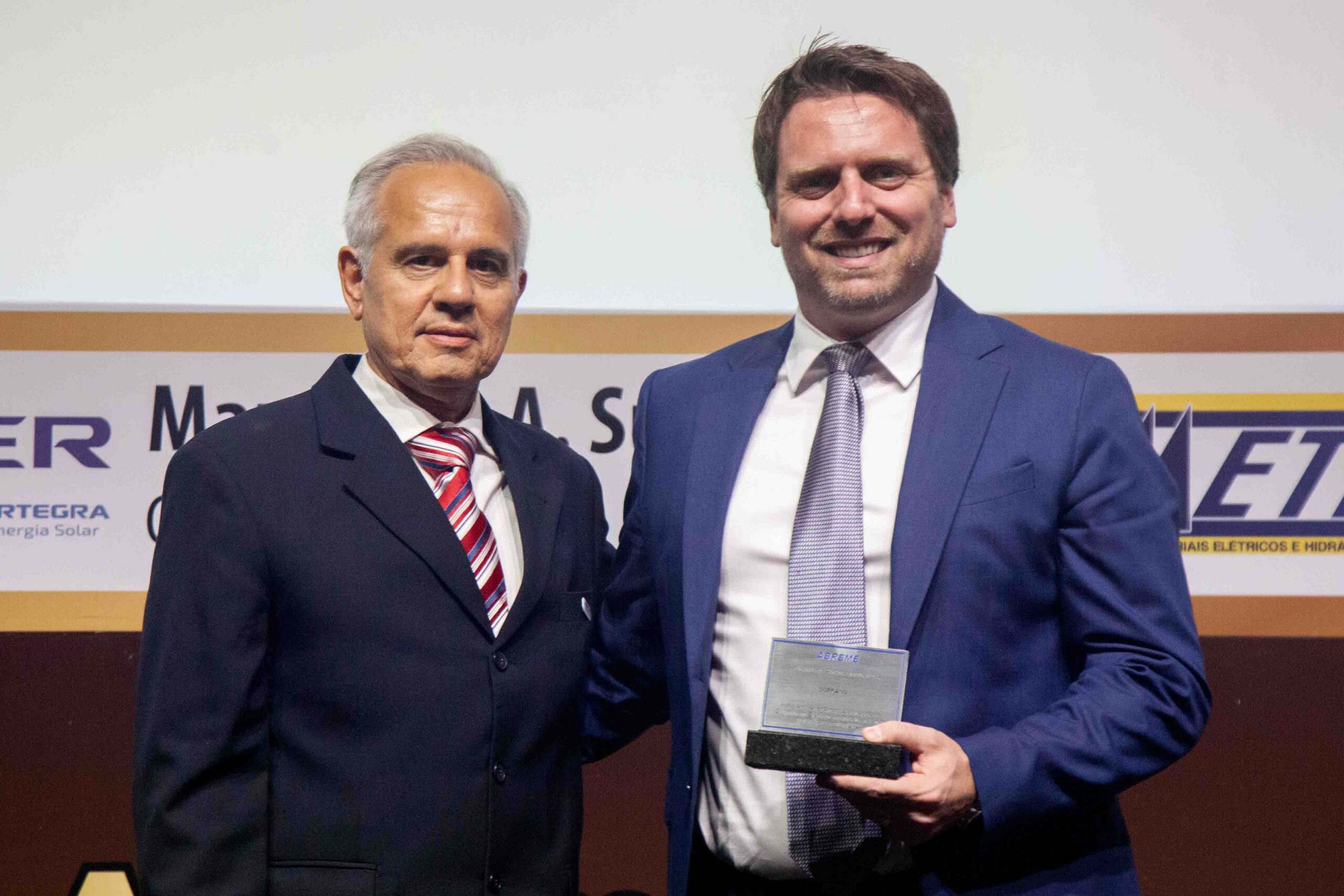 Diretor ABREME Sr. Paulo Campos entrega a placa destaque ranking 2024 no segmento Dispositivos Elétricos Industriais para empresa vencedora SOPRANO ao Sr. Marcelo Gerhardt Diretor Comercial.