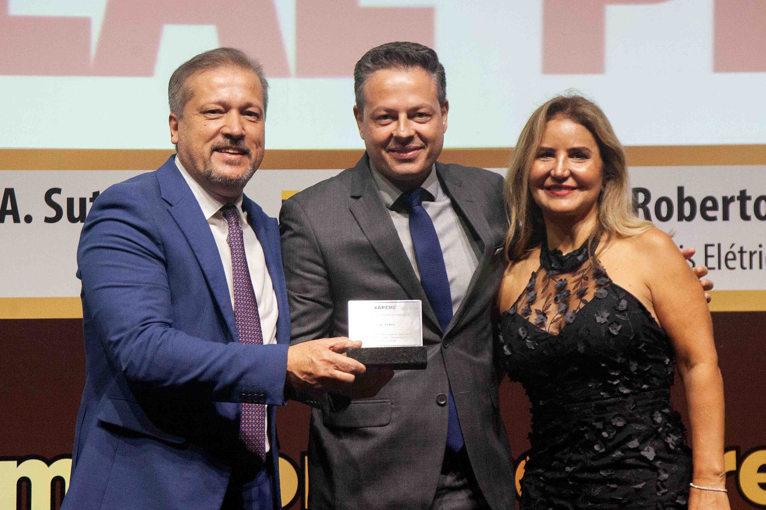 Diretor ABREME Sr. João Carlos Faria Júnior entrega a placa destaque ranking 2024 no segmento Infraestrutura empresa vencedora REAL PERFÍL ao Sra. Simone Silverio Diretora e Cláudio César Fantin CEO.